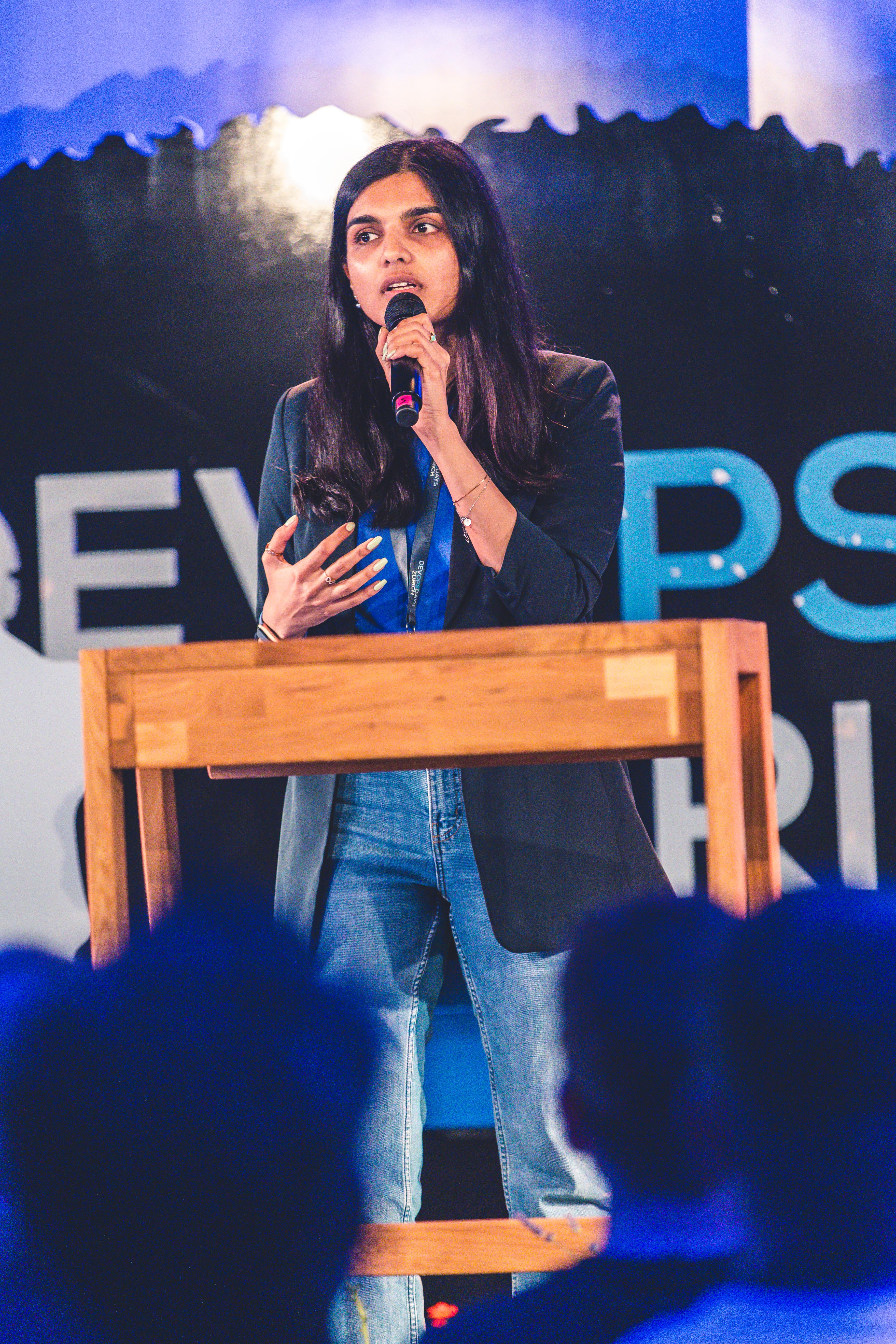 Pallavi speaking on stage at DevOpsDays Zürich